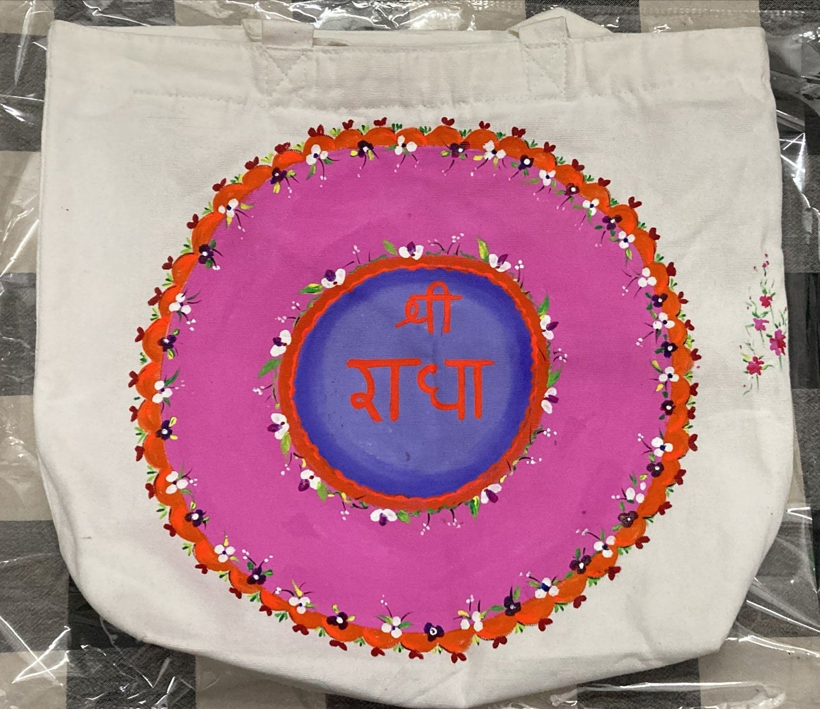 White fabric with a colorful circular design featuring text on a checkered background